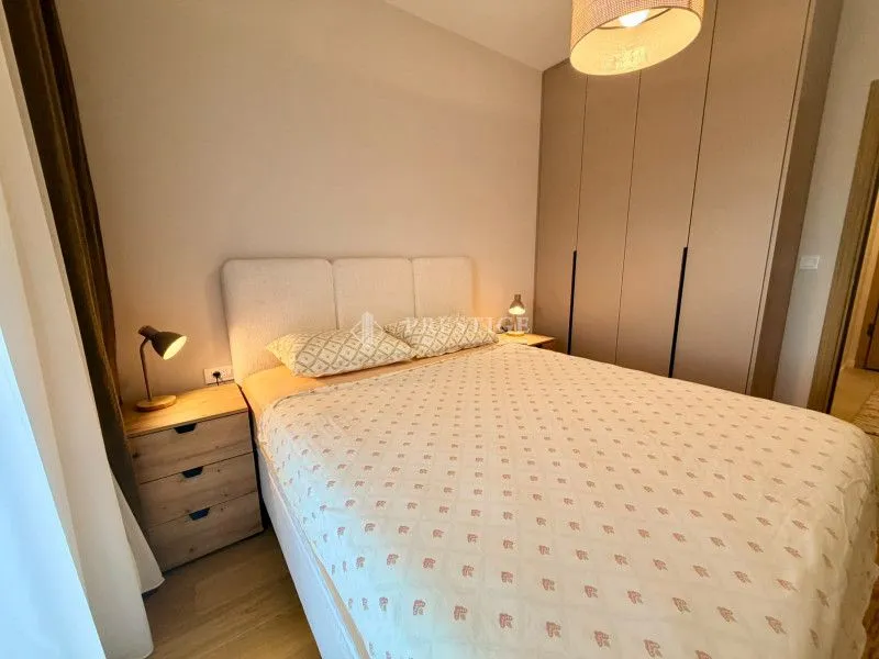 Moderna spavaća soba sa bračnim krevetom, noćnim stočićima i ugradnim plakarom.