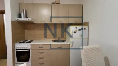 Smaller kitchen with wooden cabinetry, stove, and refrigerator. - image 2