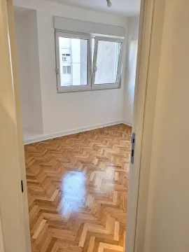Prazna soba sa parketom i prozorom, slikana kroz otvorena vrata. - image 7