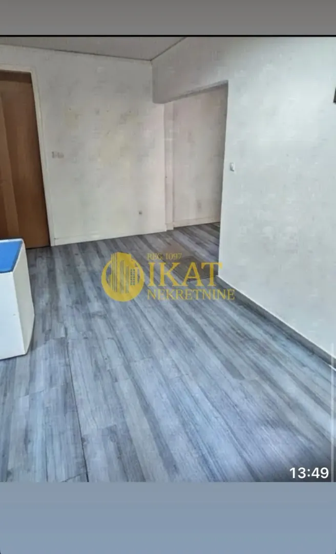 Empty room with gray laminate flooring.
