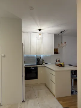 Moderna bela kuhinja sa šankom i ugrađenim elementima. - image 6