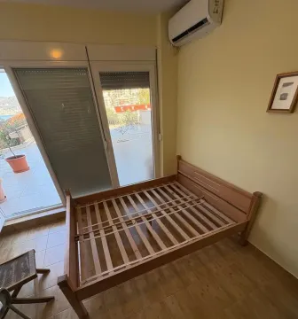Spavaća soba sa drvenim krevetom i izlazom na terasu. - image 8