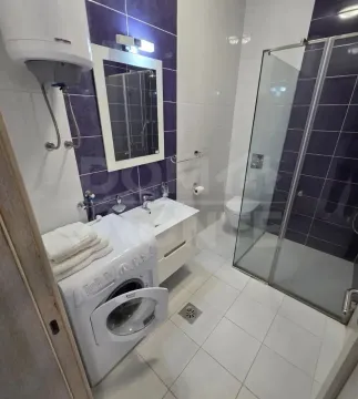 Moderno opremljeno kupatilo sa tuš kabinom i veš mašinom. - image 7