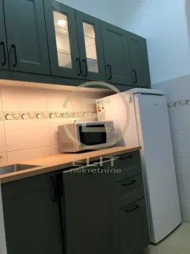Small kitchen with green cabinets, a refrigerator, and a microwave. - image 7
