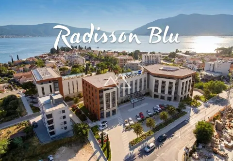 Pogled iz vazduha na hotelski kompleks sa okolnim naseljem i morem u pozadini. - image 16