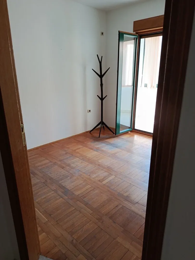 Empty room with wooden flooring and access to the terrace.