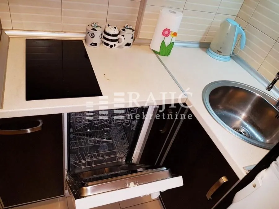 Smaller kitchen with a work surface, sink, and dishwasher.