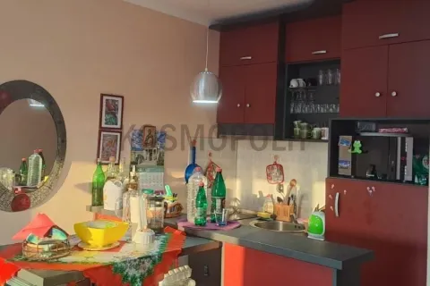 Kuhinja sa tamnim elementima i trpezarijskim stolom u uglu. - image 3
