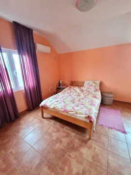 Spavaća soba sa bračnim krevetom, narandžastim zidovima i prozorom sa ljubičastim zavjesama. - image 6