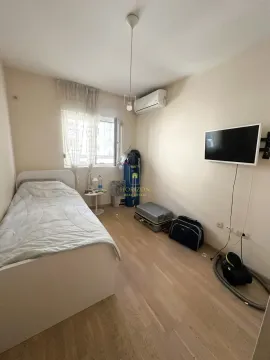 Manja spavaća soba sa krevetom, klima-uređajem i televizorom na zidu. - image 6
