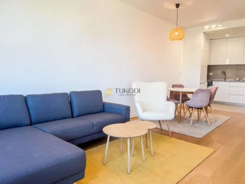 Living room with a sofa and a dining area connected to the kitchen. - image 13