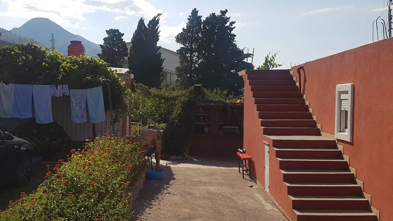 Dvorište kuće sa stepeništem i zelenilom.
