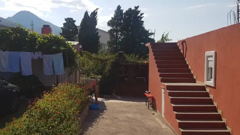Dvorište kuće sa stepeništem i zelenilom. - image 5