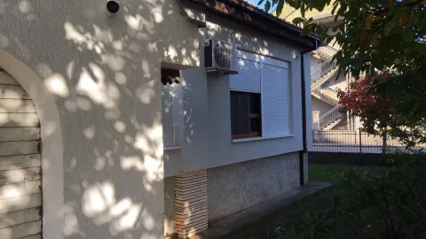 Exterior view of the house with a window, shutters, and an AC unit. - image 8