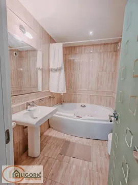 Bathroom equipped with a washbasin and a corner bathtub. - image 7