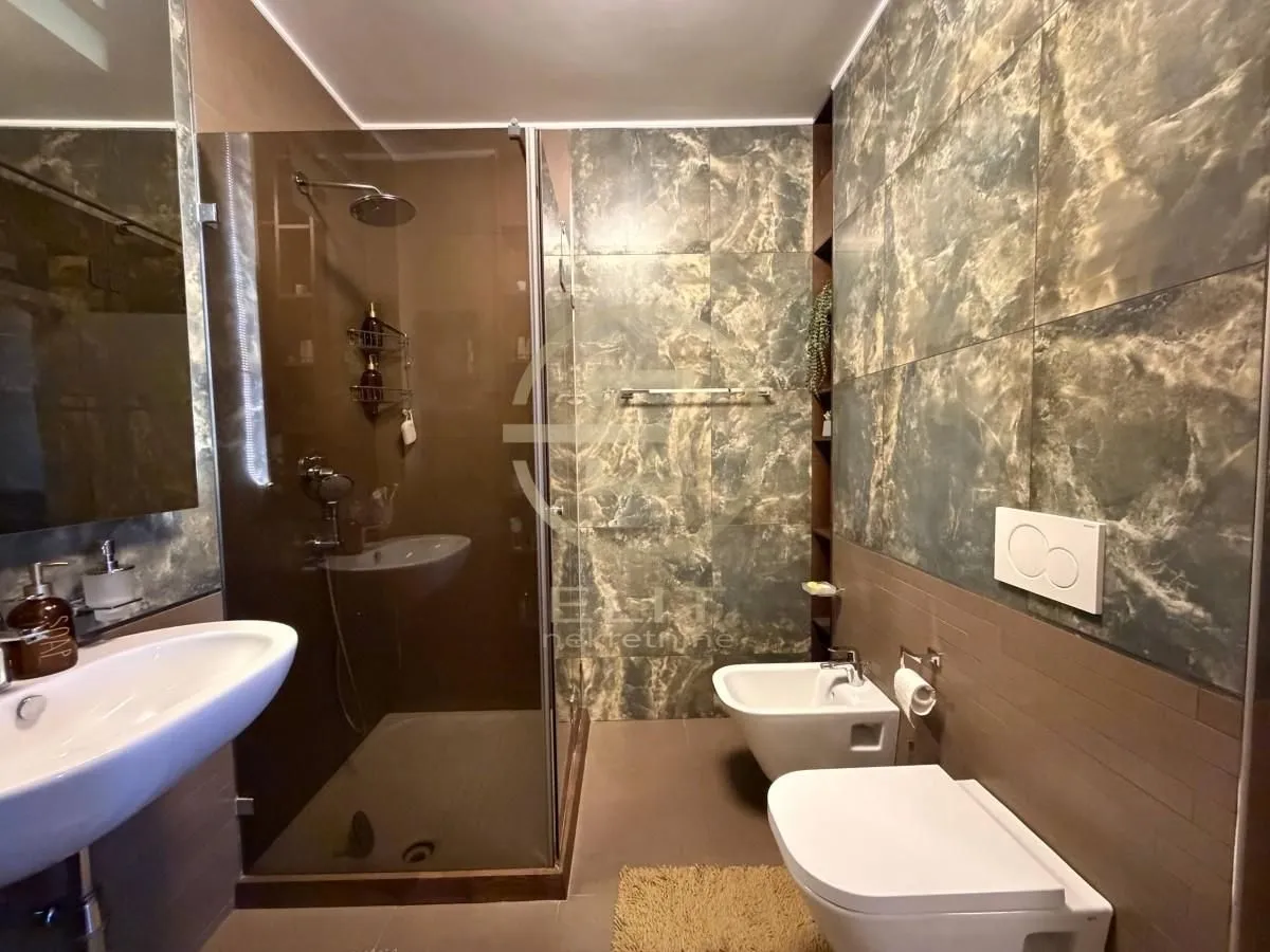 Moderno kupatilo sa tuš kabinom, umivaonikom i sanitarijama.