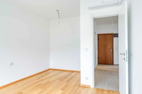 Empty bright room with wooden flooring and an open doorway leading to the hallway. - image 15