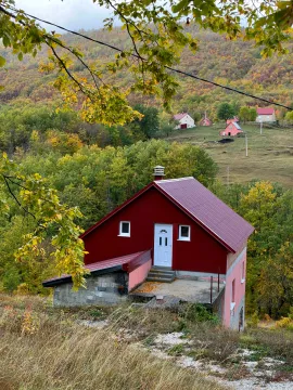 Pogled na vikendicu sa crvenim krovom u prirodi okruženoj šumom. - image 4