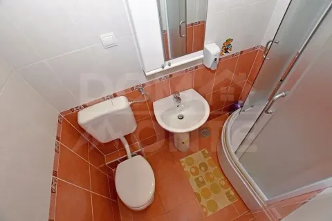 Manje kupatilo sa tuš-kabinom, umivaonikom i wc šoljom u narandžastim tonovima. - image 13