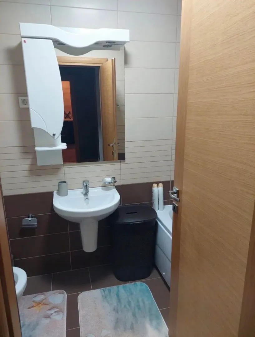 Pogled na manje kupatilo sa umivaonikom, ogledalom i sanitarijama.