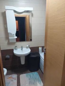 Pogled na manje kupatilo sa umivaonikom, ogledalom i sanitarijama. - image 7