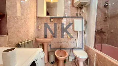 Manje kupatilo obloženo keramičkim pločicama sa kadom i sanitarijama u boji. - image 12