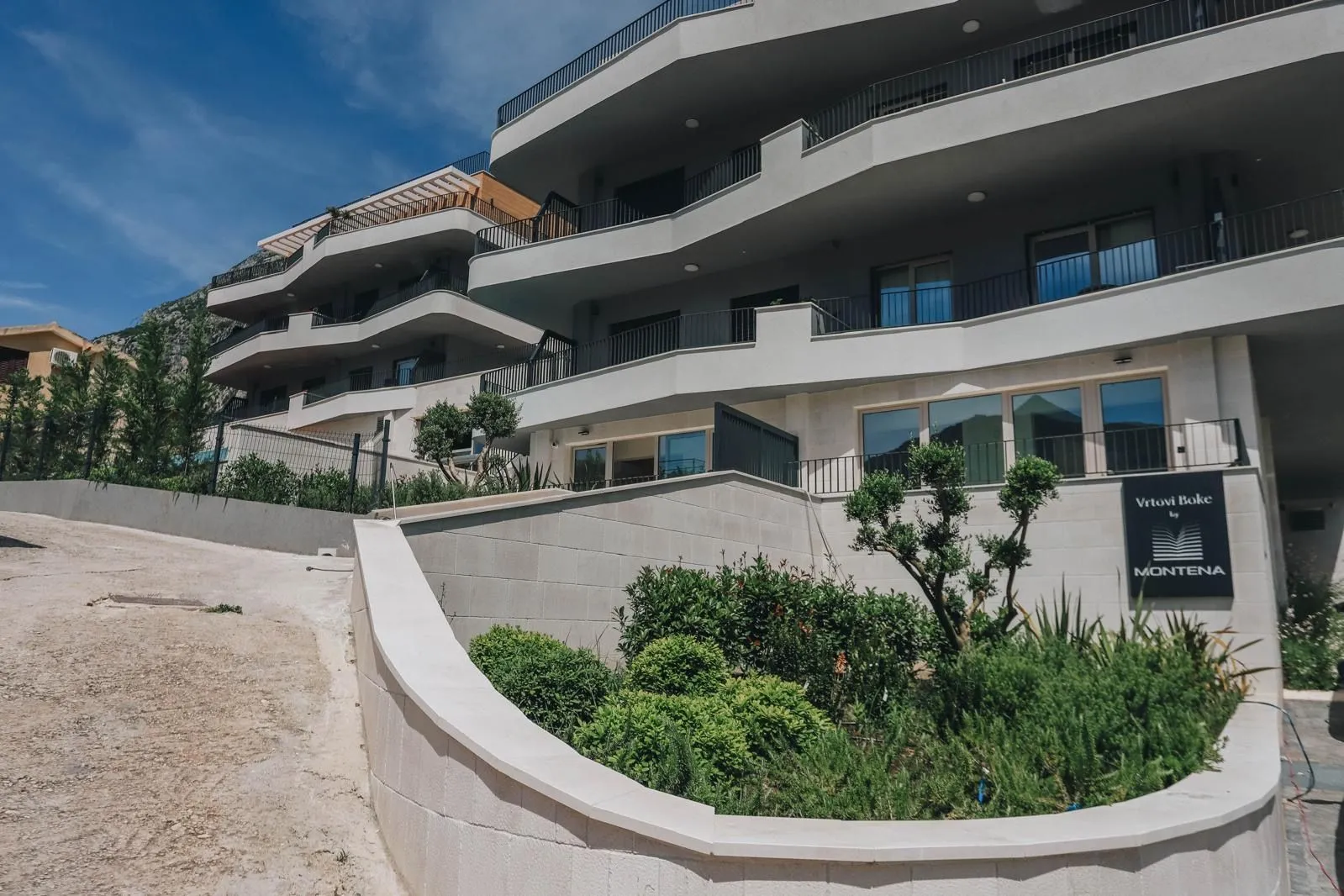 Modern residential building with landscaped courtyard and terraces.