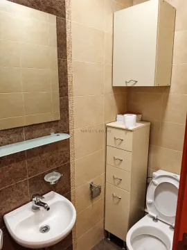 Compact bathroom equipped with a washbasin, toilet, and storage units. - image 6