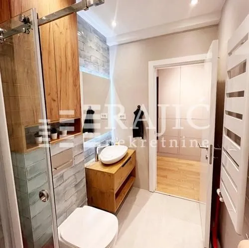 Modernly equipped bathroom with a washbasin and walk-in shower.