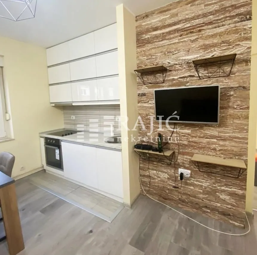 Modern kitchen with white units and a dining area.