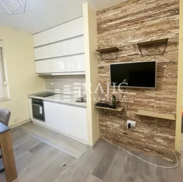 Modern kitchen with white units and a dining area. - image 4