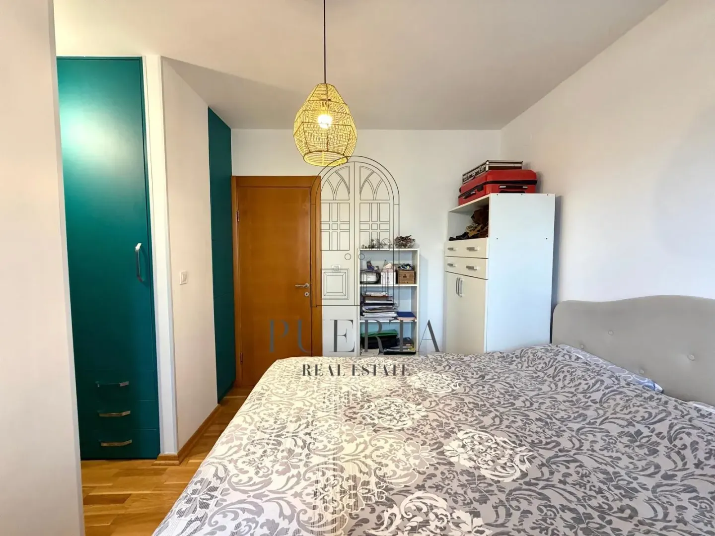 Namještena spavaća soba sa bračnim krevetom i ugradnim ormarom.