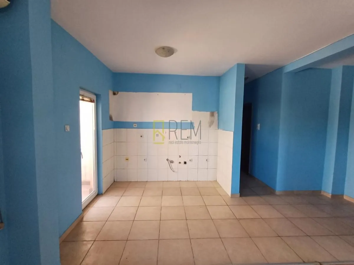 Prazna kuhinja sa pločicama i plavim zidovima.