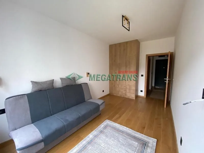 Furnished bedroom with a sofa and a built-in wardrobe.
