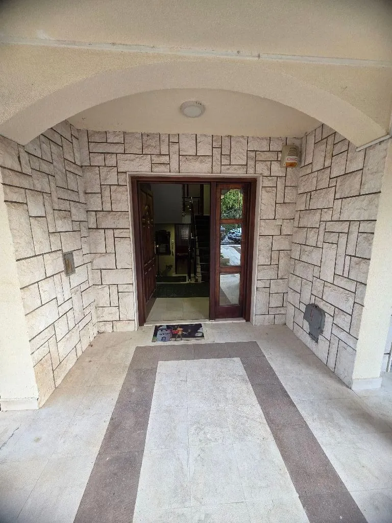 Main entrance of the building with stone facade cladding.