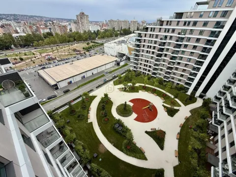 View from the terrace overlooking a landscaped park and city streets. - image 15