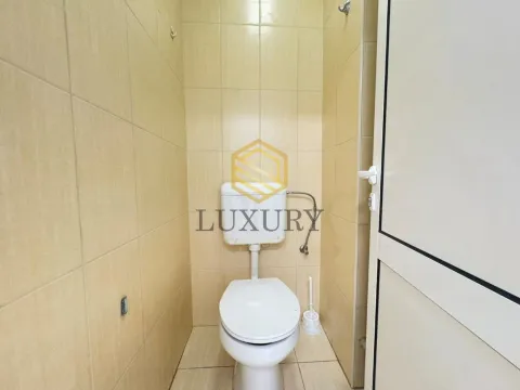 Smaller bathroom tiled with ceramic tiles featuring a toilet. - image 4