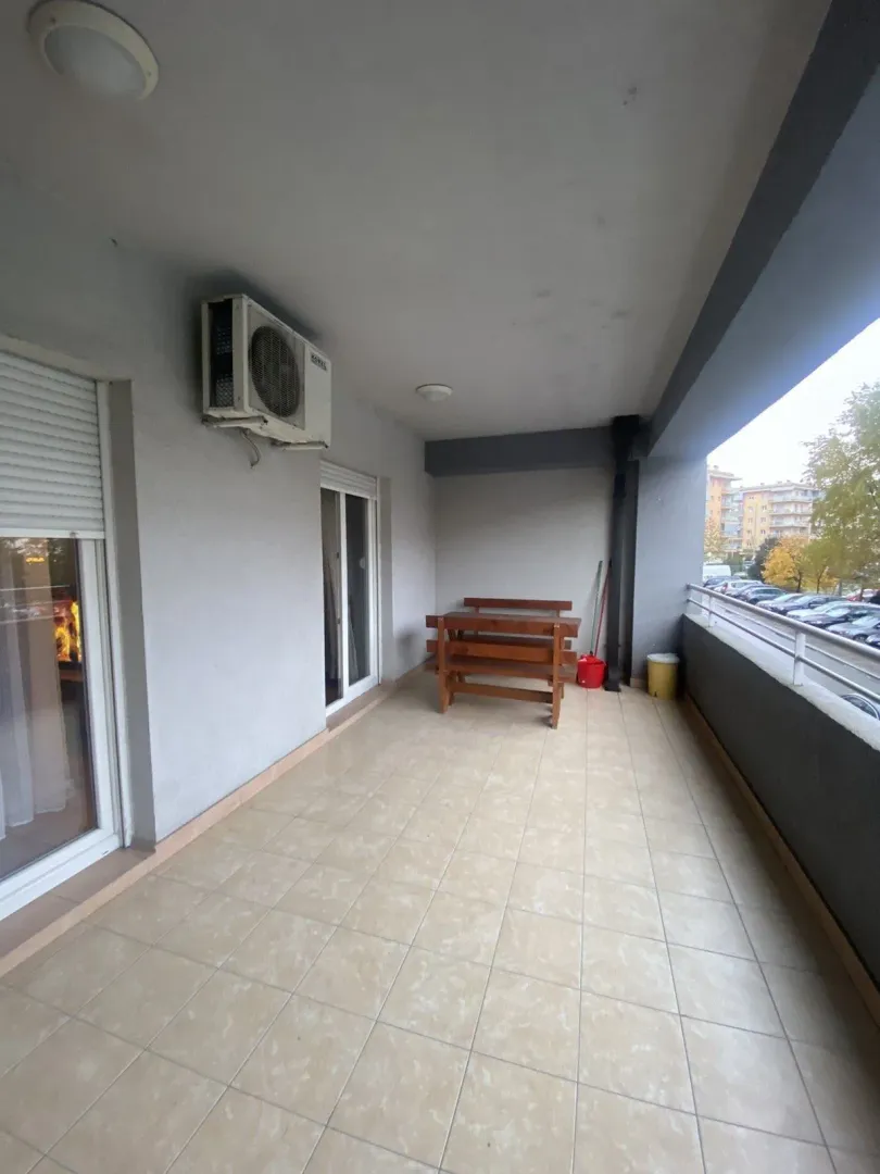 Spacious terrace with a wooden table and benches.