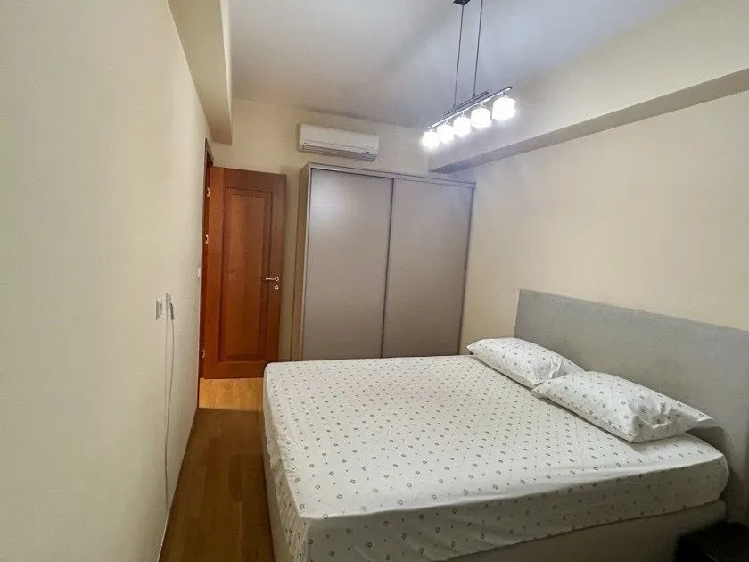 Furnished bedroom with a large double bed, wardrobe, and air conditioning.
