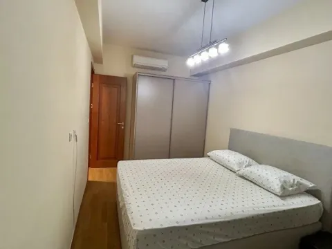 Furnished bedroom with a large double bed, wardrobe, and air conditioning. - image 6
