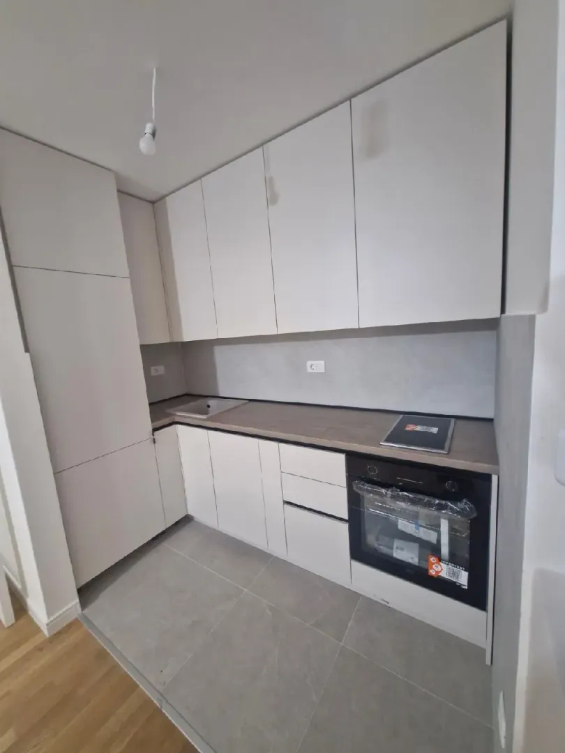 Modern white kitchen with a built-in oven.