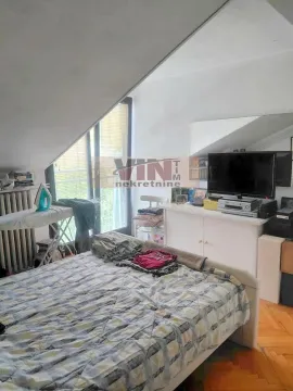 Bedroom with a bed, TV unit and sloped ceiling. - image 7
