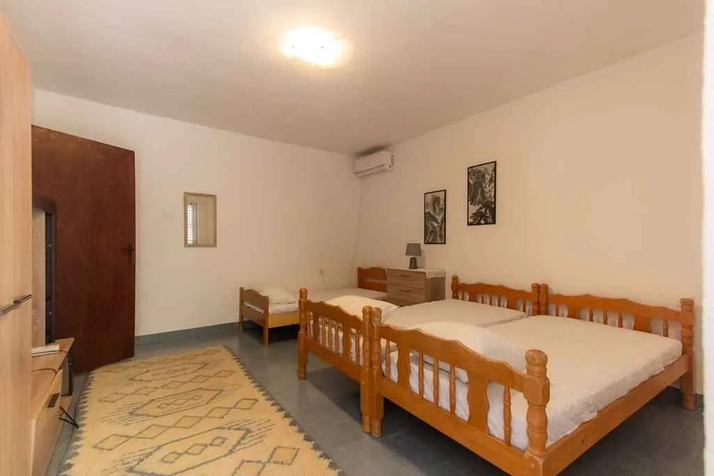 Prostrana spavaća soba sa nekoliko drvenih kreveta i tepihom.