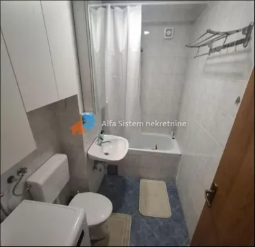 Smaller bathroom with a bathtub, washbasin, toilet, and washing machine. - image 5