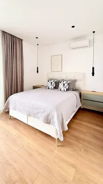 Modern bedroom with a double bed, bedside tables, and curtains. - image 10