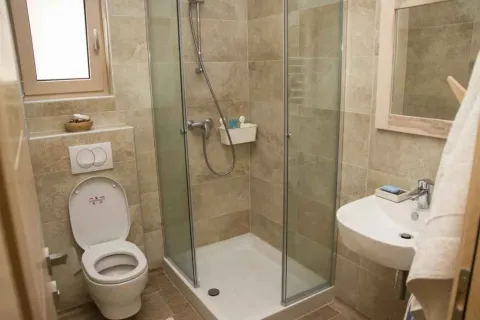 Moderno kupatilo sa staklenom tuš kabinom, umivaonikom i toaletom. - image 16