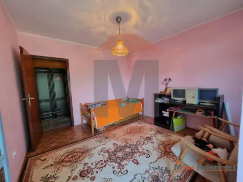 Manja spavaća soba sa krevetom, radnim stolom i roza zidovima. - image 8