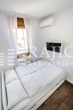 Small bedroom with a double bed, a window, and an air conditioning unit. - image 9