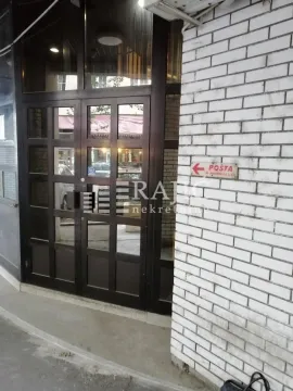 Entrance to a commercial space with dark wooden joinery and white brick on the wall. - image 10