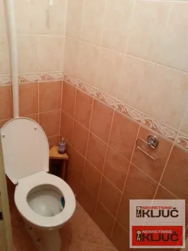 Manje kupatilo obloženo keramičkim pločicama braon tonova sa toalet šoljom. - image 6
